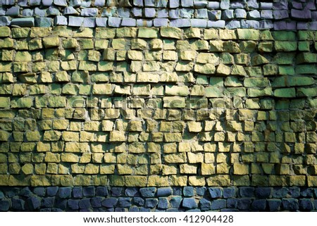 Wall decorated with mosaic tiles and colored bricks Photo executed in dark colors, the edges of a small vignette. A whimsical pattern. It can be used as the background or texture for any photo editor.