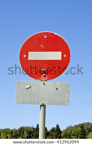 Sunlit red stop sign against blue sky