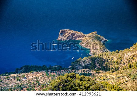 Beautiful landscape picture with rocky mountains and sailboats near the ring-shaped cliff, Mallorca, Spain.