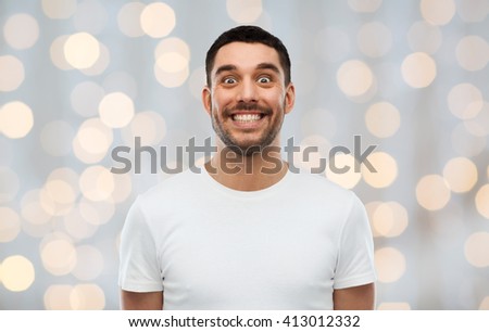 expression, emotions and people concept - man with funny face over holidays lights background