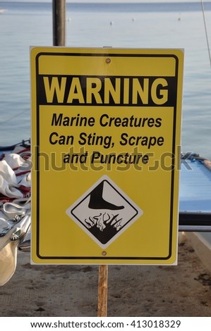 Warning marine creatures can sting, scrape and puncture sign