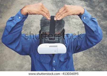 Senior man using VR glasses
