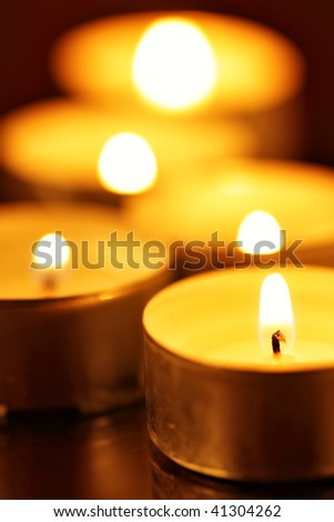 Burning warm candles close-up on a table