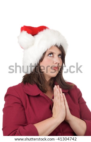 Young woman in Santa hat prays; isolated on a white background.