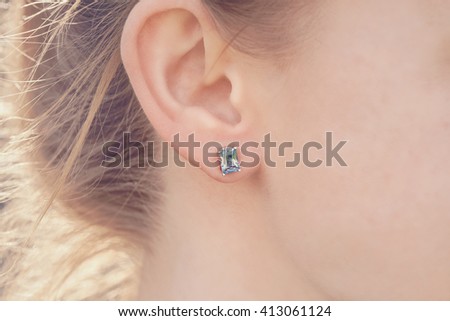 Detail of young woman wearing beautiful luxury earring  Royalty-Free Stock Photo #413061124