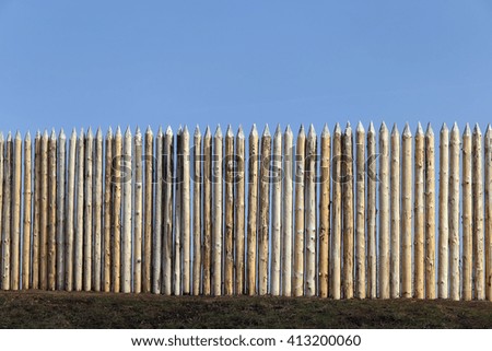 isolated close-up of a wooden palisade on the background of blue sky