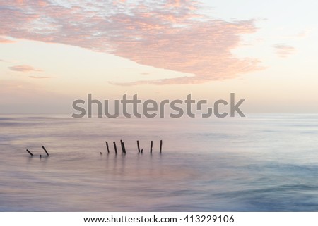 old jetty piles at St. Clair Beach in Dunedin at dawn, New Zealand