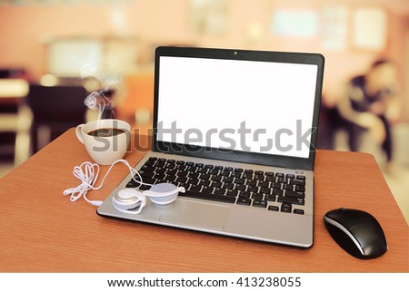 laptop and headphone on table with blur office background