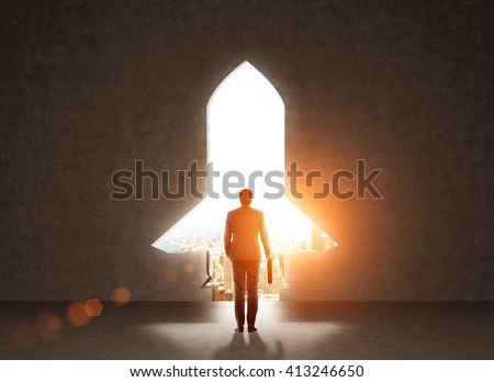 Start up concept with businessman holding briefcase and standing in front of rocket shaped gap in wall, revealing sunlit New York city view Royalty-Free Stock Photo #413246650