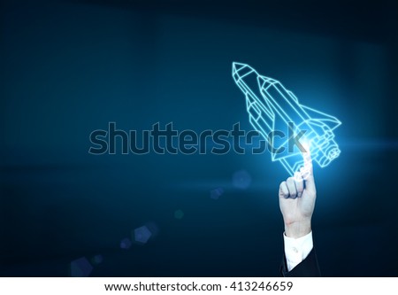 Startup concept with businessman hand holding abstract rocket ship on dark blue background Royalty-Free Stock Photo #413246659
