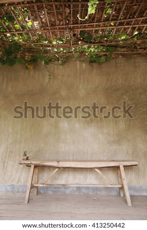  wood bench and concrete wall and plant roof