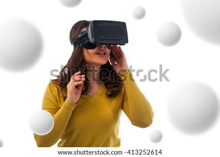 Young woman using the virtual reality headset on white background  immersed in interactive virtual reality video game 