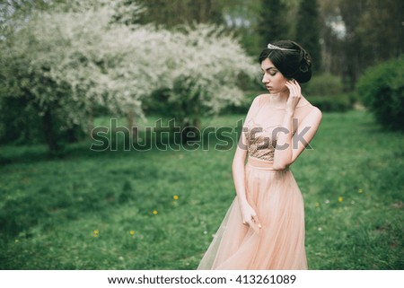 Beautiful girl posing near blossoming tree in spring