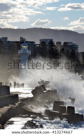 Big waves splashing over the breakwater and lighthouse in Wollongong Harbour