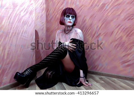 vampire girl with bare shoulders posing on a red background