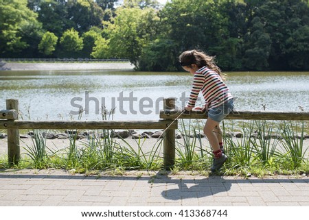 Girl playing in the banks of the pond