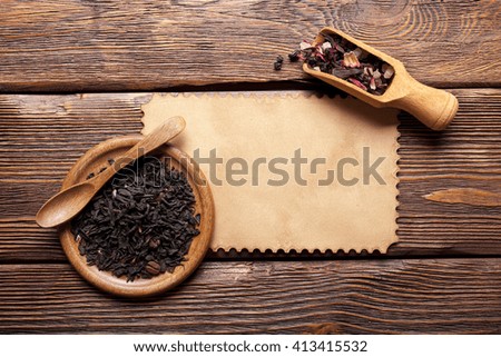 Blank paper card and dry tea leaves
