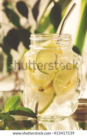 Homemade lemonade in mason jar over summer background, selective focus. Toned image