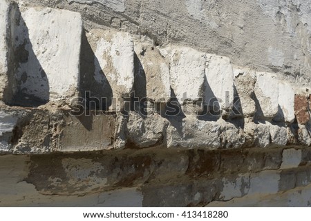 White brick wall with cracked plaster casts shadow, background