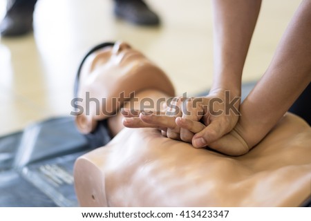 CPR training medical procedure - Demonstrating chest compressions on CPR doll in the class  Royalty-Free Stock Photo #413423347