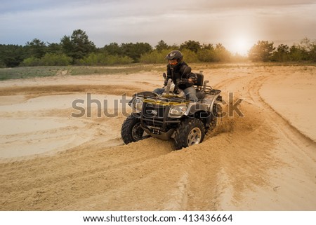 Racing ATV is sand.  Royalty-Free Stock Photo #413436664