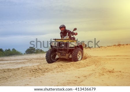 Racing ATV is sand.  Royalty-Free Stock Photo #413436679