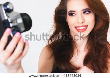Image of cute girl make a photo selfi at vintage camera. Take a photograph of herself. Funny, party. Beauty. Happy girl smiling. Makeup and hairstyle