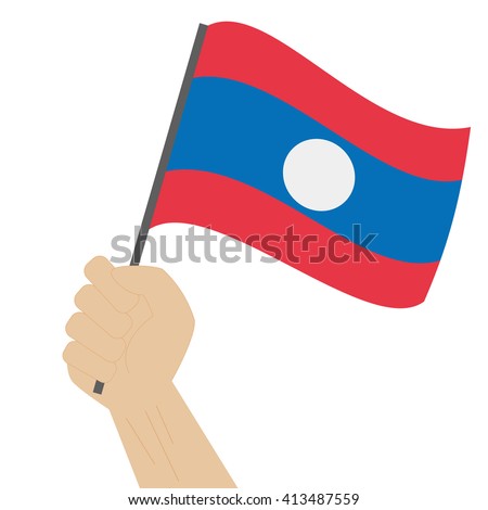 Hand holding and raising the national flag of Laos