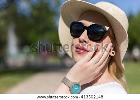 Portrait of woman with hat and sunglassess outside