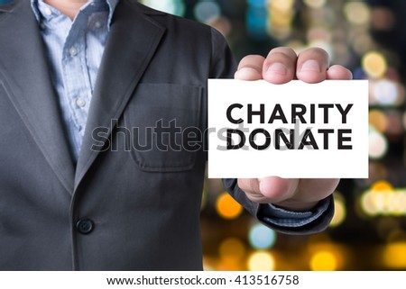 CHARITY DONATE Give Concept Businessman message on the card shown on blurred city background,