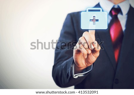 Businessman touching and pressing first aid icon in the air with finger