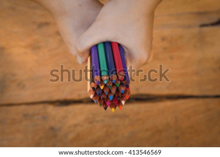  hand keep color pencil on wood background