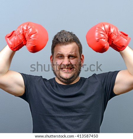 Portrait of chubby boxer posing with boxing gloves as a champion