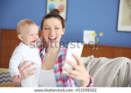Young mother taking a selfie with her baby