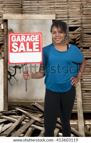 Beautiful woman holding a garage sale sign