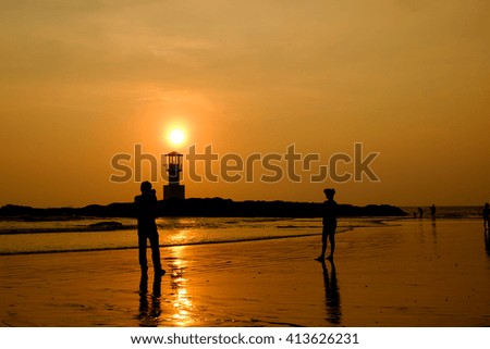 Silhouette of family on the beach at sunset