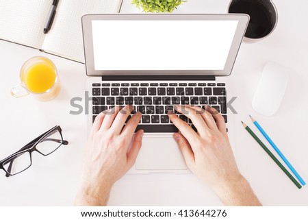 Topview of businessperson hands typing on laptop with blank white screen on desktop with orange juice, coffee, glasses and other items. Mock up