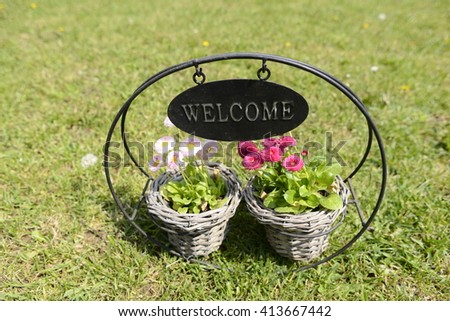 Welcome mat pancard with colorful flowers, green grass in a family garden atmosphere.  Perfect beckground for any image.