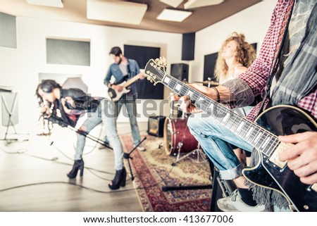 Rock band recording a music track in a studio - Friends performing music in a recording studio