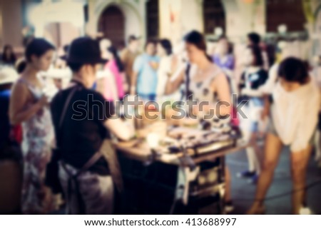 Blurred people buying food on the street at night for background