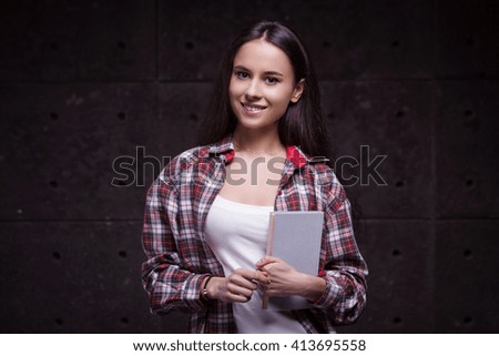 Portrait of stylish beautiful young woman. Woman smiling and holding book