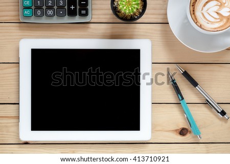 Office workspace with tablet blank screen,pens, coffee cup and calculator .Top view with copy space.Office supplies and gadgets on desk table.Office workspace concept.Flat lay images.