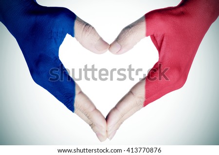 closeup of the hands of a young woman forming a heart patterned as the flag of France, with a vignette added