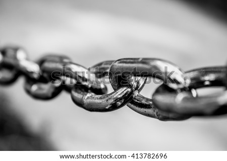 Black and white close up shot to a stretched chain. Royalty-Free Stock Photo #413782696