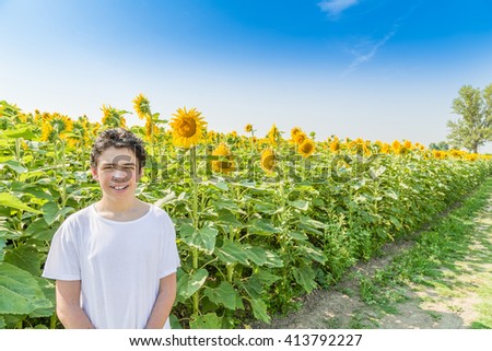 Natural and healthy living, Caucasian boy smiling in front of a field of sunflowers