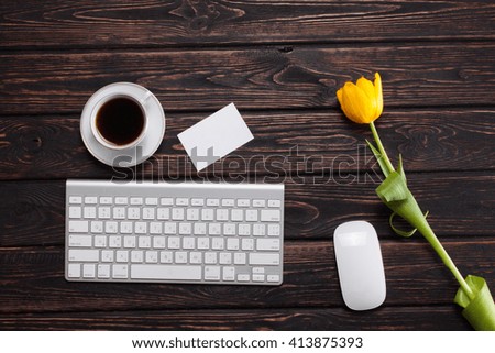 Keyboard with tulips on the table. The first spring flowers on the boards