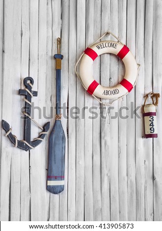 Composition on the marine theme with anchor, paddle and lifeline on old wooden background