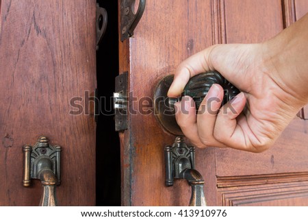 Hand opening the door knob Royalty-Free Stock Photo #413910976