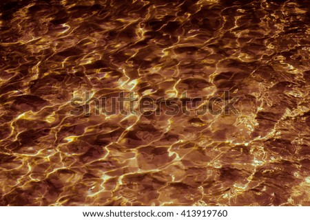 Abstract patterned gold surface water in the pool.