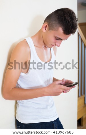 Teenager burying in mobile phone and social networking indoors
 Royalty-Free Stock Photo #413967685